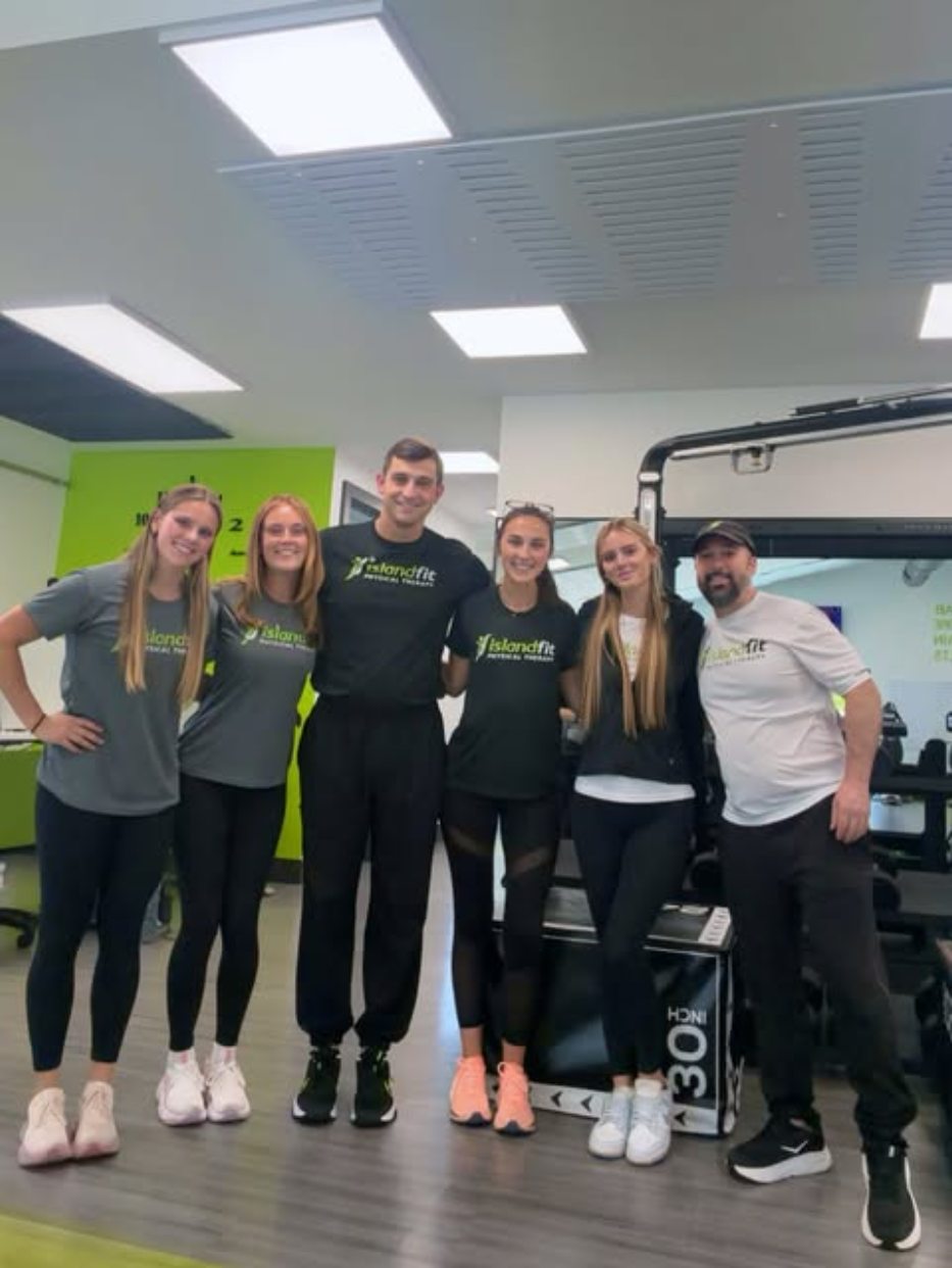 The IslandFit team in matching IslandFit shirts inside the clinic