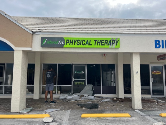 The IslandFit Physical Therapy storefront sign in Santini Plaza after the storm